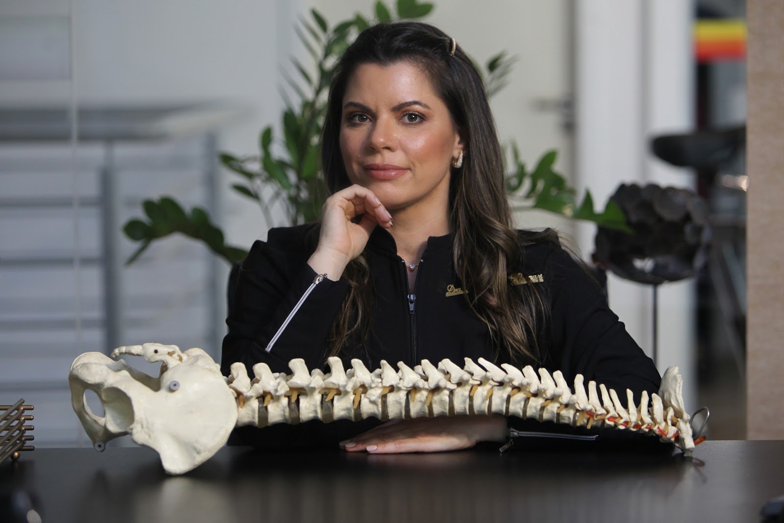 Dra. Fernanda Marques com um modelo anatômico da coluna vertebral no Instituto Valens